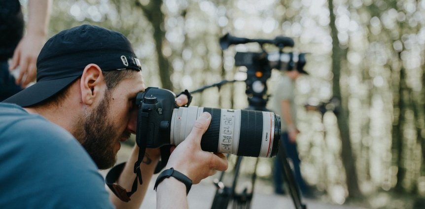 Photographer using a telephoto lens to capture outdoor wedding moments